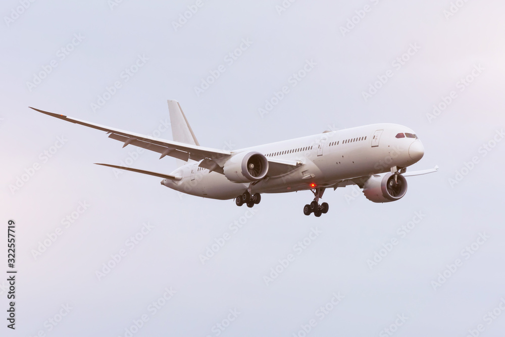 Large white passenger airplane landing approach airport.