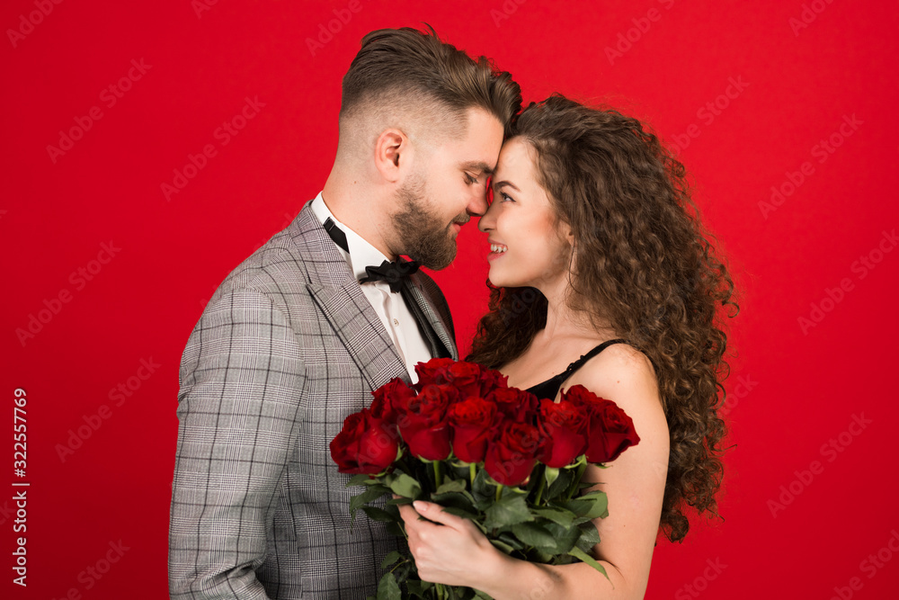 Side view of romantic couple with flowers isolated on red background Side view of romantic couple with flowers isolated on red background