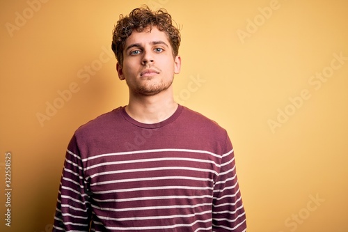 Wallpaper Mural Young blond handsome man with curly hair wearing casual striped sweater Relaxed with serious expression on face. Simple and natural looking at the camera. Torontodigital.ca