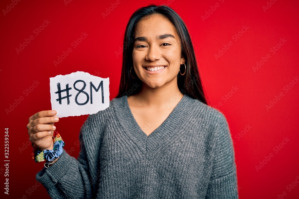 Young beautiful asian woman celebrating 8th march womens day holding reminder paper with a happy face standing and smiling with a confident smile showing teeth Young beautiful asian woman celebrating 8th march womens day holding reminder paper with a happy face standing and smiling with a confident smile showing teeth