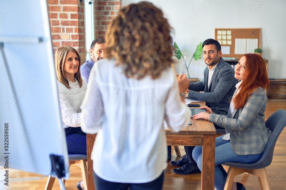 Group of business workers working together in a meeting. One of them making presentation to colleagues at the office Group of business workers working together in a meeting. One of them making presentation to colleagues at the office