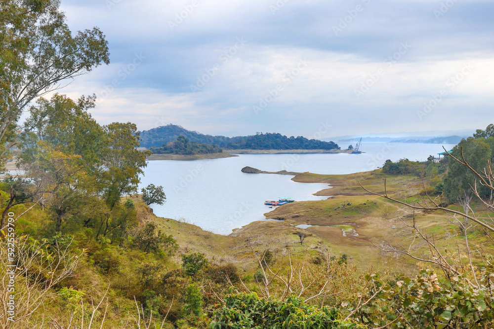 Obraz premium Beautiful lake with boats, covered with mountain and forest