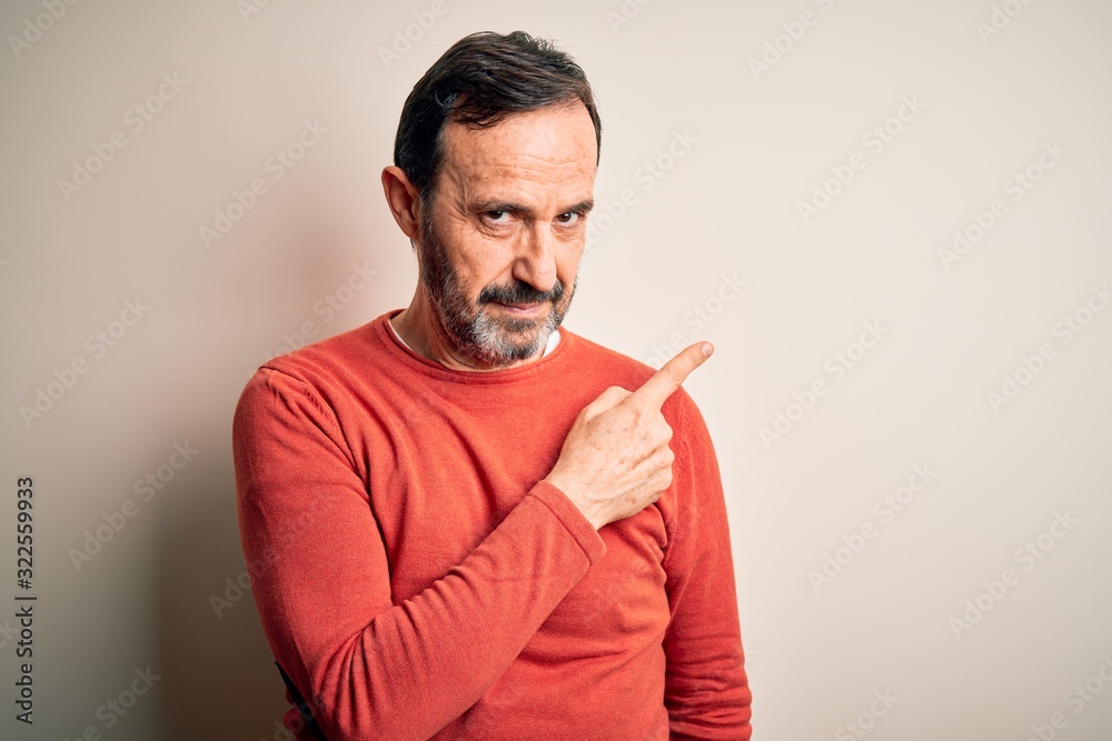 Middle age hoary man wearing casual orange sweater standing over isolated white background Pointing with hand finger to the side showing advertisement, serious and calm face Middle age hoary man wearing casual orange sweater standing over isolated white background Pointing with hand finger to the side showing advertisement, serious and calm face