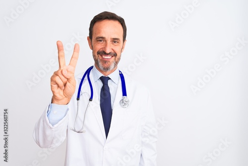 Middle age doctor man wearing coat and stethoscope standing over isolated white background showing and pointing up with fingers number two while smiling confident and happy.
