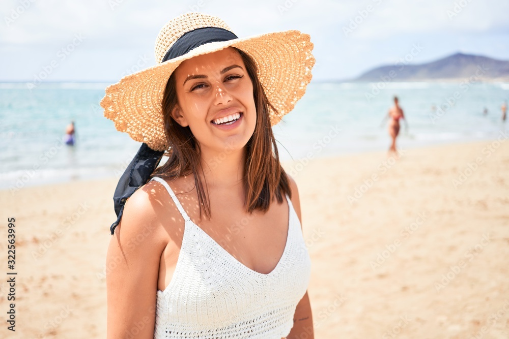Young beautiful woman smiling happy enjoying summer vacation at the beach