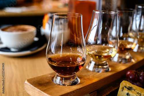 Flight of Scottish whisky, tasting glasses with variety of single malts or blended whiskey spirits on distillery tour in Scotland