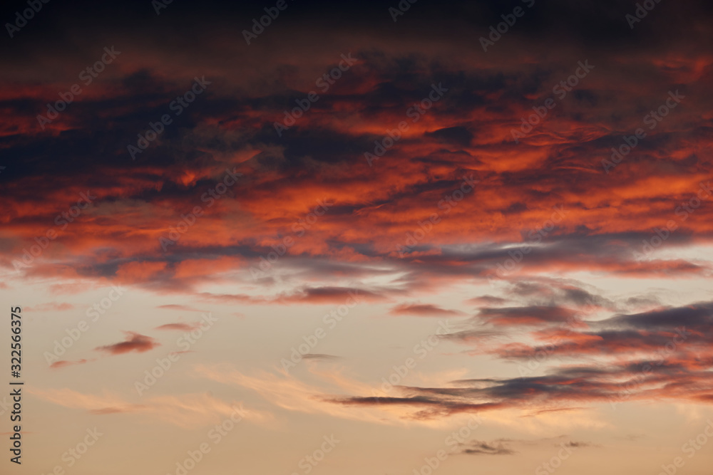 beautiful dramatic sky with dark and bright clouds at sunset, summer landscape, golden sunlight