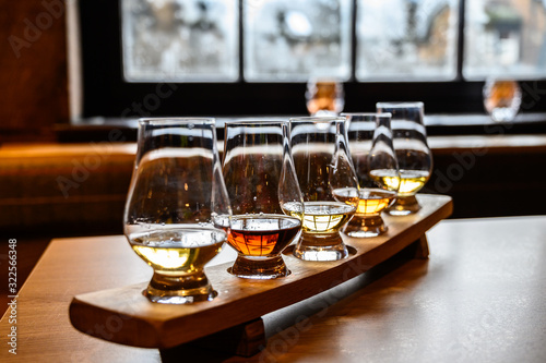 Flight of Scottish whisky, tasting glasses with variety of single malts or blended whiskey spirits on distillery tour in Scotland