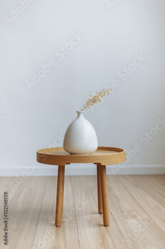 branch in white vase white wood table background cozy interior