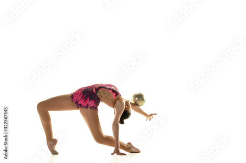 Young flexible girl isolated on white studio background. Teen-age female model as a rhythmic gymnastics artist practicing with equipment. Exercises for flexibility, balance. Grace in motion, sport.