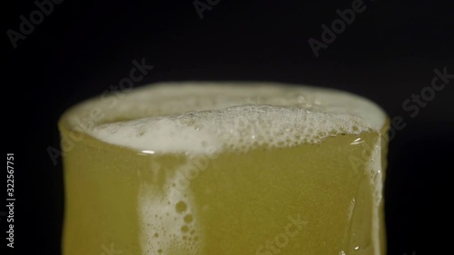 Light foam beer is poured into a transparent glass