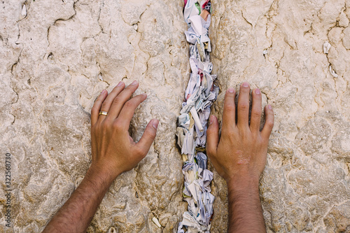 Closeup of hands on top of notes to god ,  at the The Western Wall, Wailing Wall, or Kotel in Jerusalem , Israel