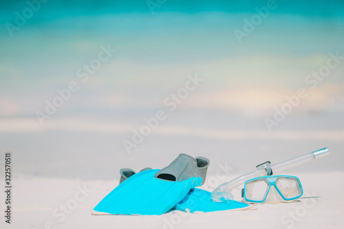 Snorkeling equipment mask, snorkel and fins on white beach
