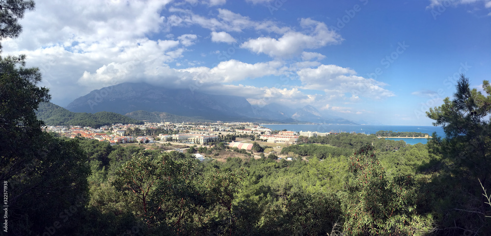 Panoramic view from observing place point to Kemer city in Antalya region surrounded by high mountains and blue calm Mediterranean sea on bright sunny day
