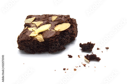 Chocolate brownie with sliced almond nuts toppings crumbs isolated on white background.