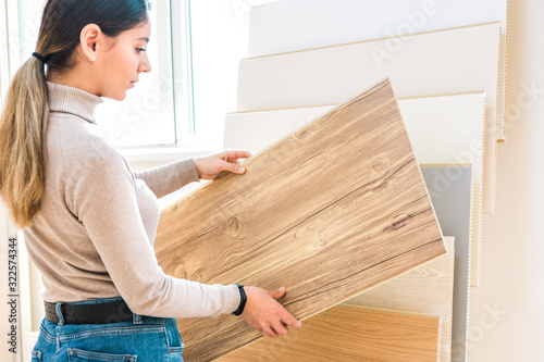 home repair. portrait of woman choosing wood laminated flooring in shop