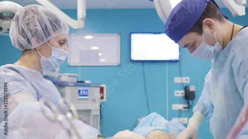 The surgeon performs an operation with an assistant in the clinic. Liposuction, lipomodeling. photo