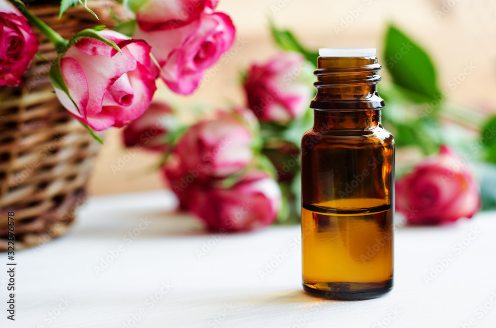 Small glass bottle with essential rose oil. Aromatherapy, spa and herbal medicine ingredients. Copy space. Small glass bottle with essential rose oil. Aromatherapy, spa and herbal medicine ingredients. Copy space.