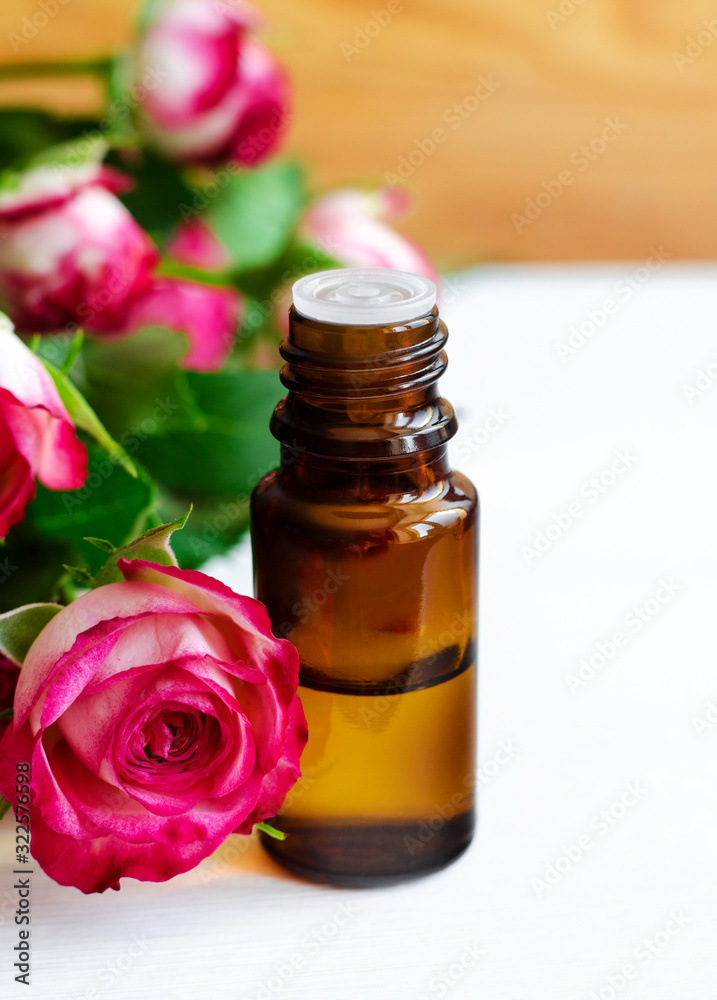 Small glass bottle with essential rose oil. Aromatherapy, spa and herbal medicine ingredients. Copy space. Small glass bottle with essential rose oil. Aromatherapy, spa and herbal medicine ingredients. Copy space.