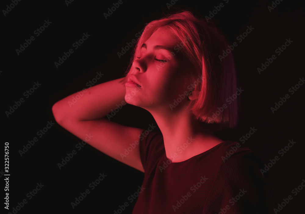 portrait of an impulsive girl with a Bob haircut in neon red and purple light