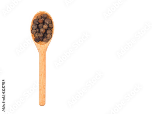 Spice allspice in wooden spoon isolated on white