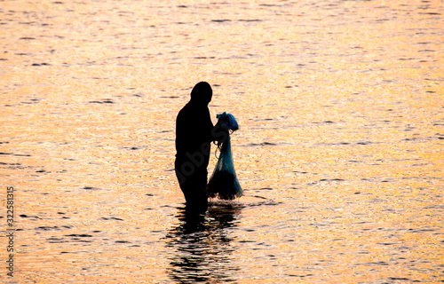 The fisherman cast a net the sea in the morning, at sunrise, Songkhla province, Thailand country