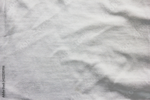 Crumpled white cloth texture, used fabric sheet background. Cotton material  surface, grunge light grey clothing pattern. Wrinkle on elegant shirt for men and women, blanket or sheet, close up