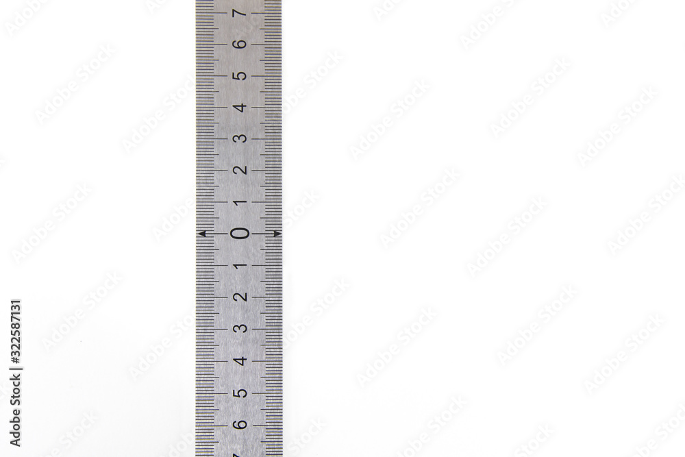 Metal ruler on a white isolated background with black numbers and scale. Vertically positioned, zero in the middle of the scale. Precise measuring tool. High quality photo. Metal ruler on a white isolated background with black numbers and scale. Vertically positioned, zero in the middle of the scale. Precise measuring tool. High quality photo.