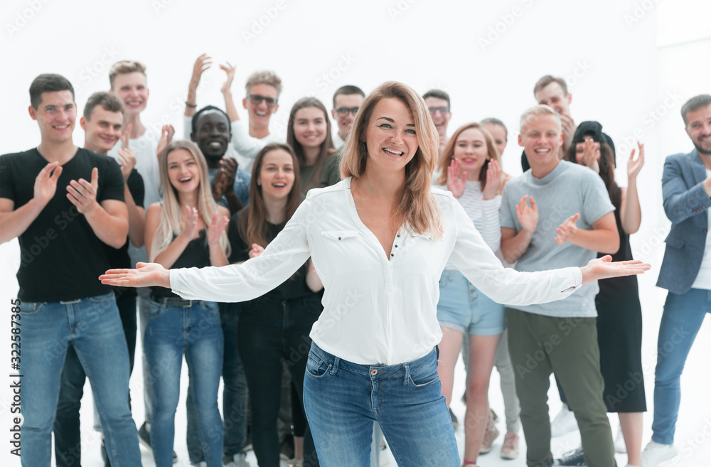 happy young woman standing in front of applauding team