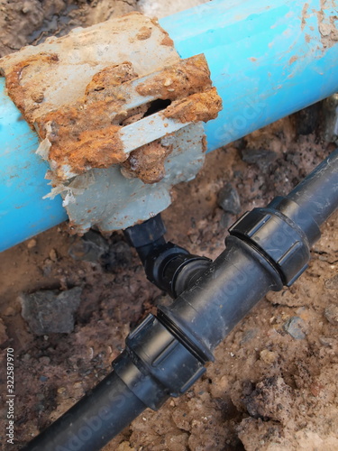 Black plastic plumbing pipe fitting. Compression PB pipe that connects the main plumbing and sub-plumbing. On the ground background. .grab lock fitting.Selective focus