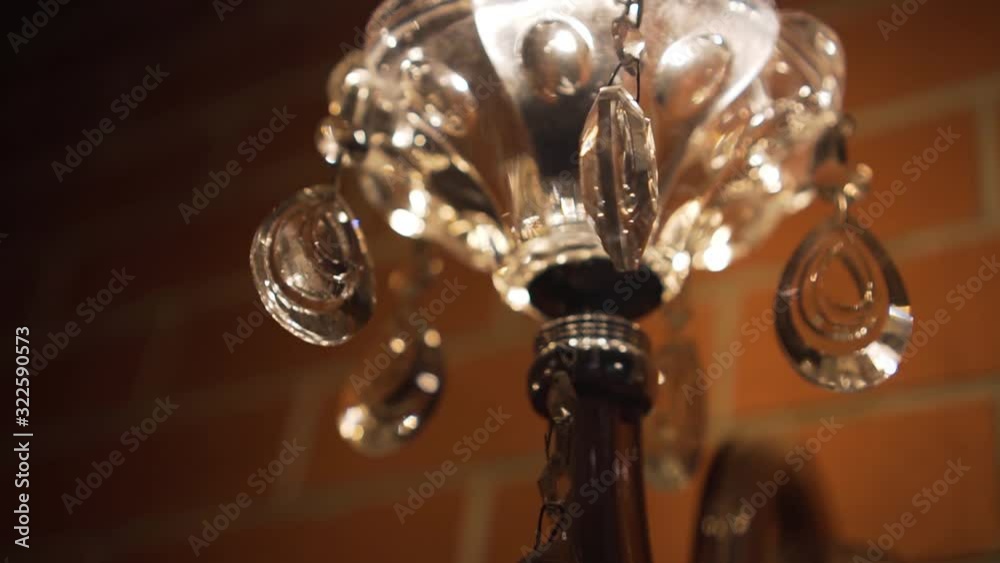 A crystal wall lamp with crystals shimmers with bright lights, the camera rotates around it. A crystal wall lamp with crystals shimmers with bright lights, the camera rotates around it.