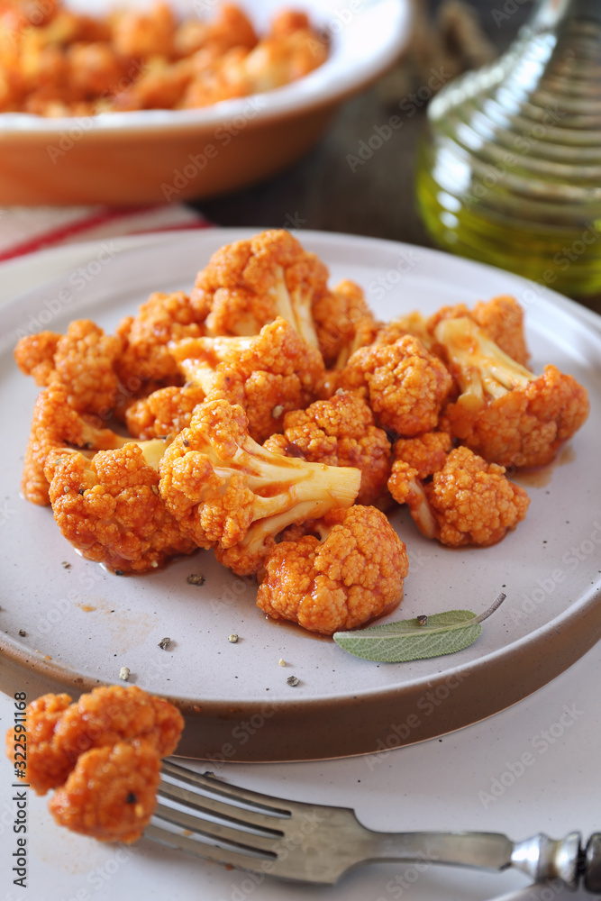 Vegetarian cuisine: spicy roasted cauliflower in tomato sauce and olive oil Vegetarian cuisine: spicy roasted cauliflower in tomato sauce and olive oil