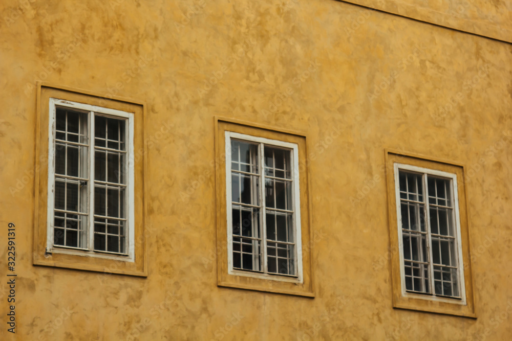 Prague, Czech Republic. 10.05.2019: Detail of the yellow facade of a historic building in the old town of beautiful Prague, Czech Republic. Golden hourly photograph. The sun shines on the facade.