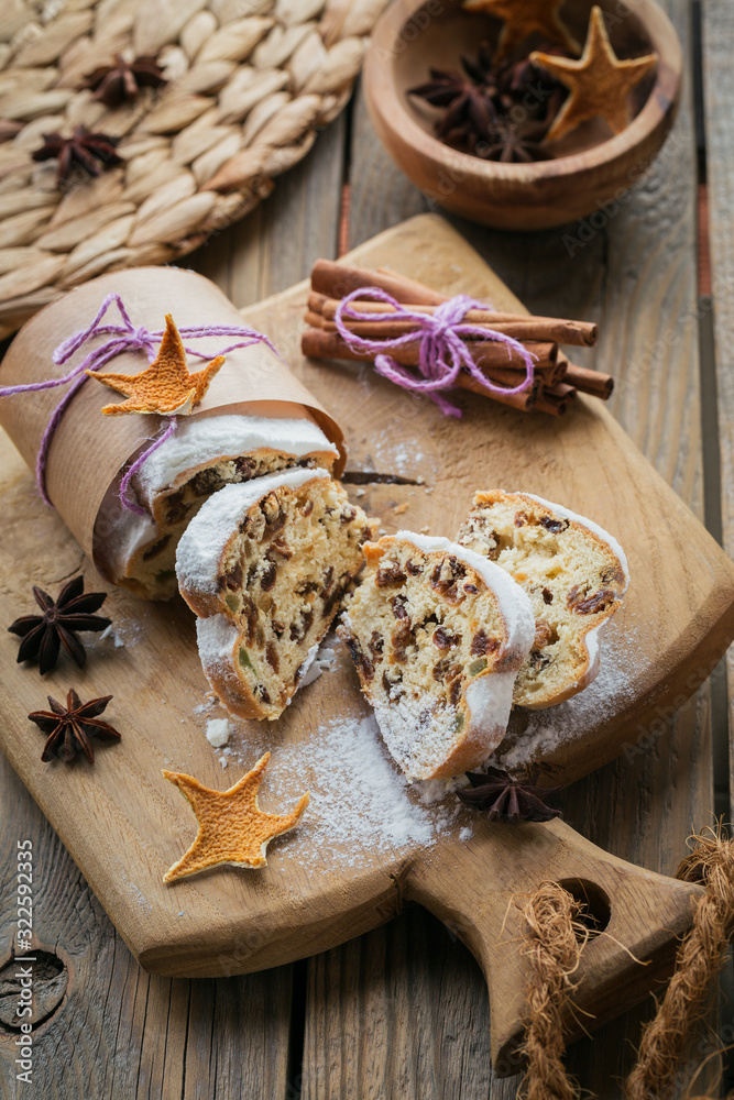 Homemade traditional christmas dessert stollen with dried berries, nuts and powdered sugar on top