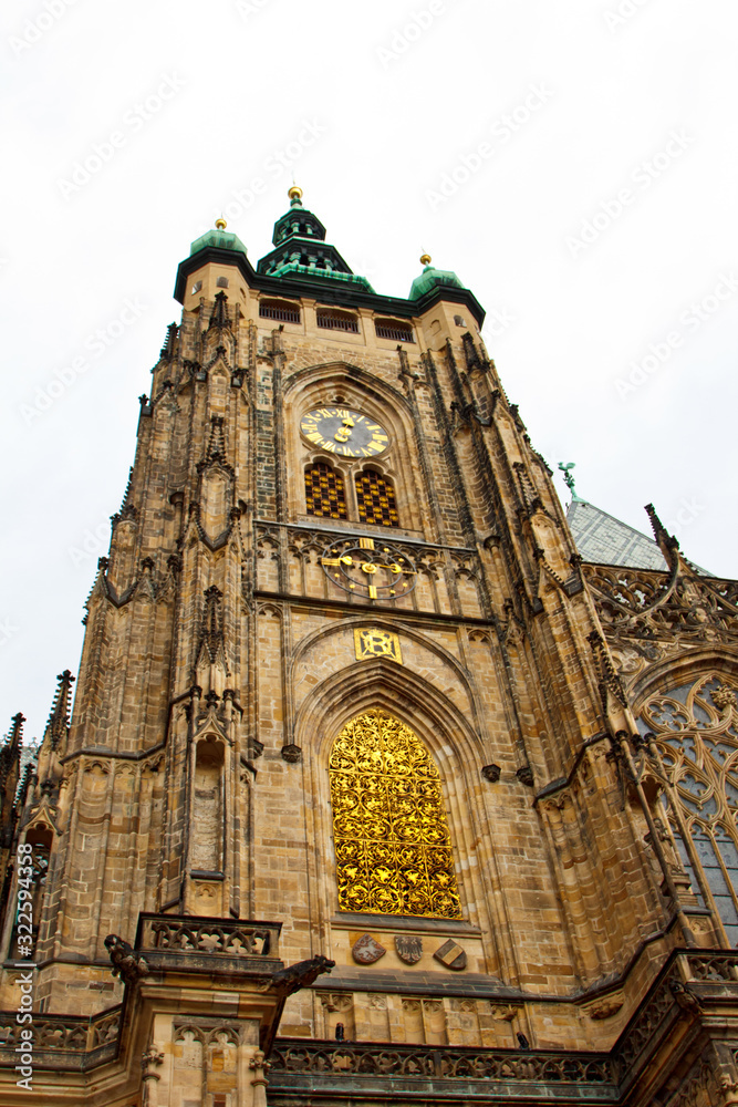Obraz premium Prague. 05.10.2019: Perspective view of the Metropolitan Cathedral of Saints Vitus, Wenceslaus and Adalbert, an excellent example of Gothic architecture. Golden Gate South Tower with clock.