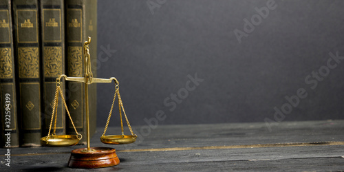 Law concept - Open law book with a wooden judges gavel on table in a courtroom or law enforcement office isolated on white background. Copy space for text