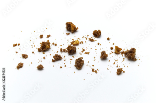 Scattered crumbs of chocolate chip butter cookies on white background.