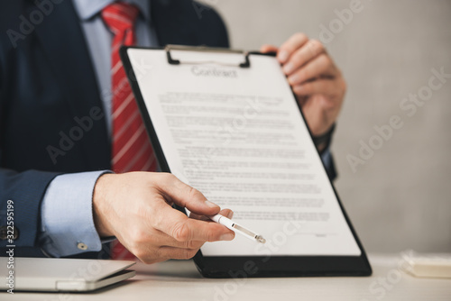 cropped view of agent holding clipboard with contract lettering and pen