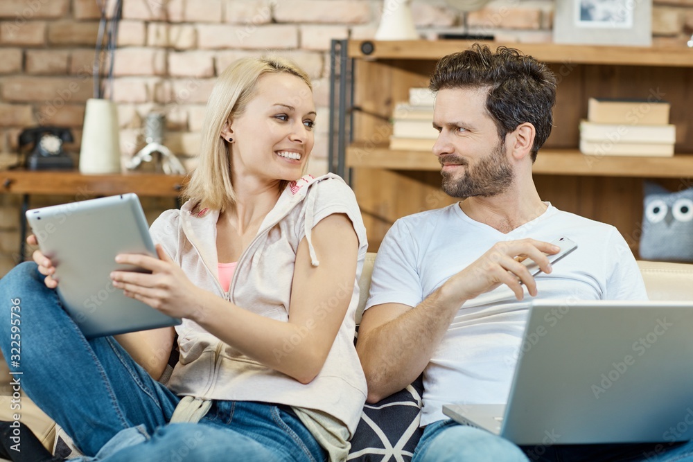 Young couple with laptop mobile and tablet Young couple with laptop mobile and tablet
