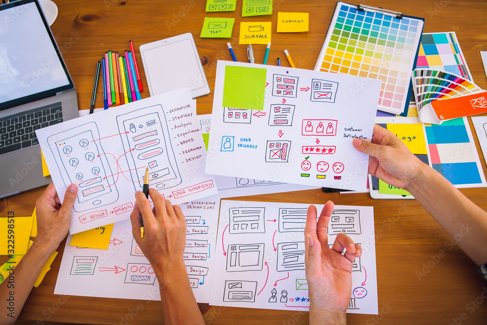 Obraz premium The web designer team is helping to design applications for mobile phones. UX UI designer concept