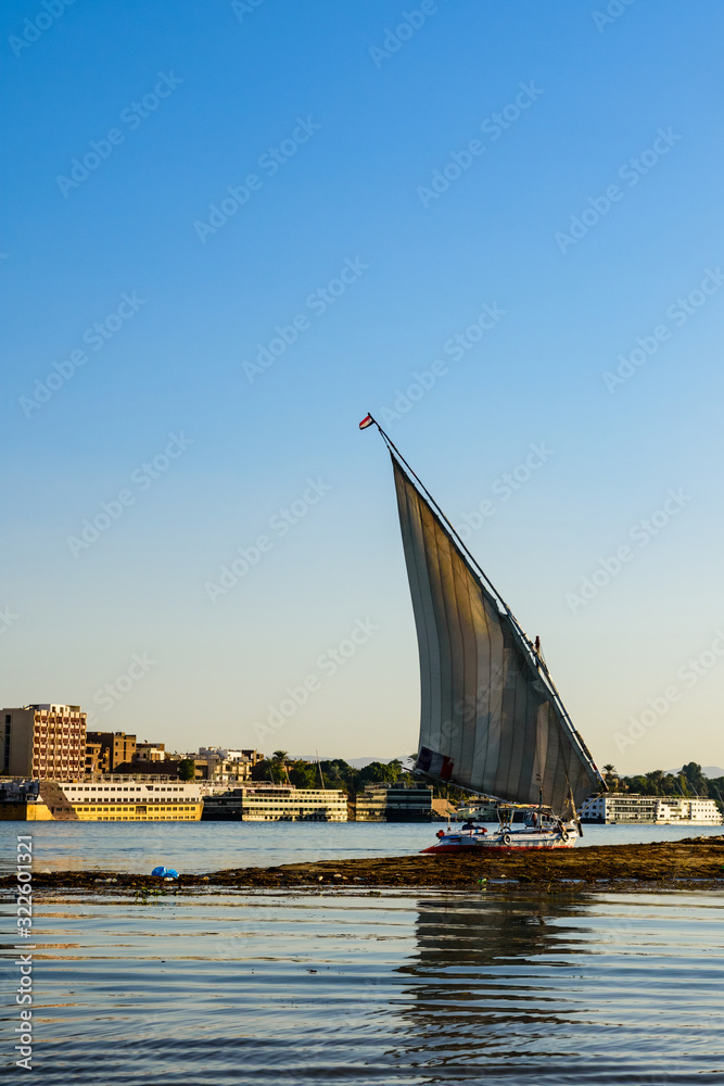 Traditional egyptian vessel felucca moored near the bank of Nile river in Luxor, Egypt Traditional egyptian vessel felucca moored near the bank of Nile river in Luxor, Egypt