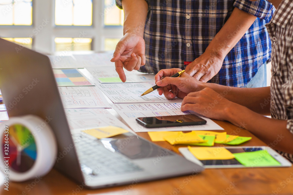 The web designer team is helping to design applications for mobile phones. UX UI designer concept The web designer team is helping to design applications for mobile phones. UX UI designer concept