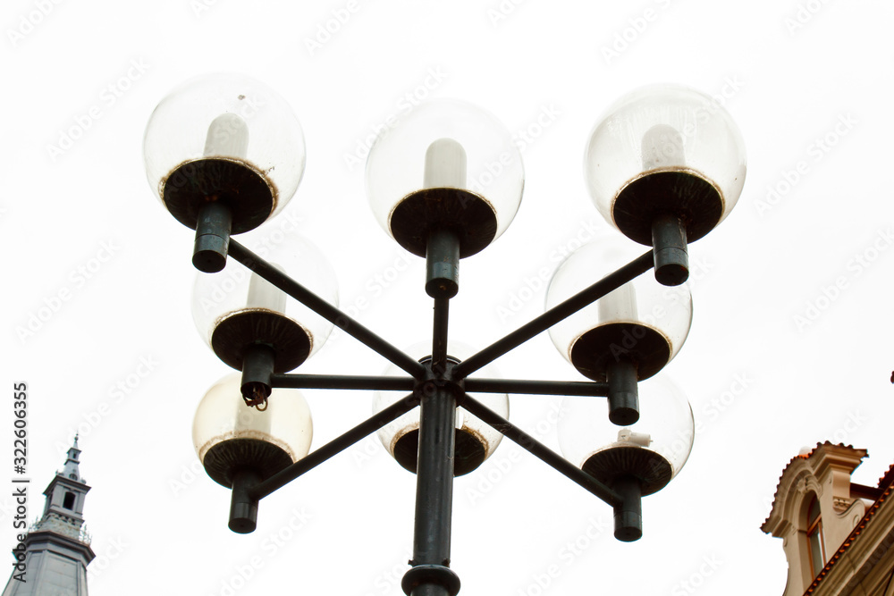 Prague. 05.10.2019: Prague street lamp. Wrought iron flashlight on the background of buildings on the wall. Prague. 05.10.2019: Prague street lamp. Wrought iron flashlight on the background of buildings on the wall.