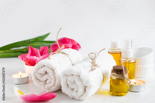 Spa and wellness concept. Accessories for spa procedures towels  essential oils  candles and aromatic flowers. Skin care concept.