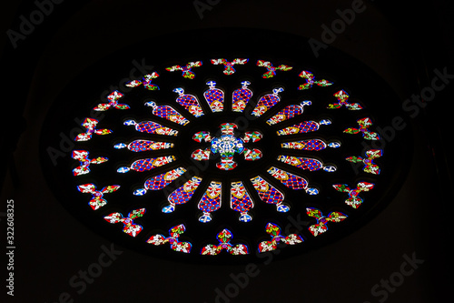 Circular shape stained glass window inside Arucas cathedral in Gran Canaria, Spain. Colorful mandala style decoration over black background. Catholic religion concept