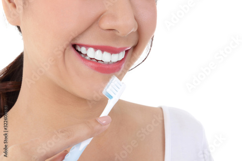 Beautiful smiling woman  clean white teeth  pink lips  hold a toothbrush. Oral care concept. White background