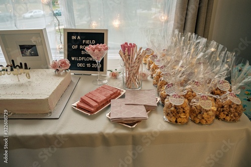 Dessert table with party favors, marshmallow, wafers cookies and sticks, cake and table napkin,