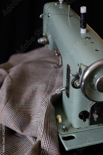 sewing machine with a jacket in a cage on a black background