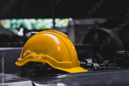Yellow hard safety helmet hat and dark background. Engineer, Construction and Safety Concept. Copy Space.