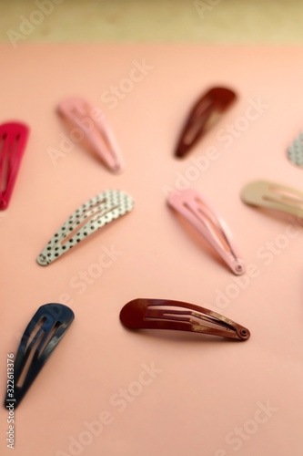 Colorful trendy hair clips on bright pink background. Selective focus.